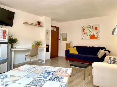 a living room with a blue couch and a table at Piscina en Centro de Terrassa in Terrassa