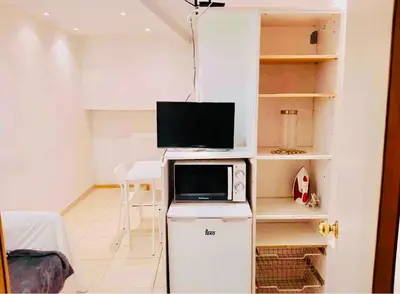 a room with a microwave and a television on a refrigerator at 06 DUPlEX LOFT in Barcelona