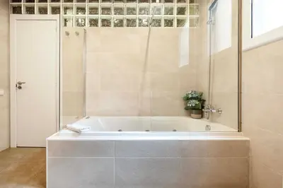 a bathroom with a bath tub with a glass door at Sagrada familia Secret Apartment in Barcelona