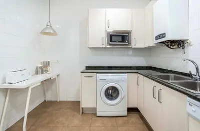 a kitchen with a washing machine and a sink at Sagrada familia Secret Apartment in Barcelona