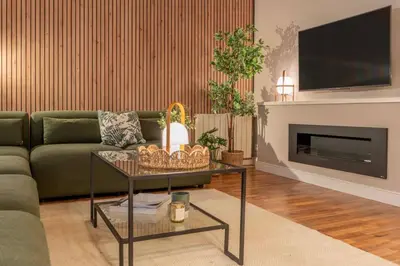 a living room with a green couch and a fireplace at Sagrada familia Secret Apartment in Barcelona