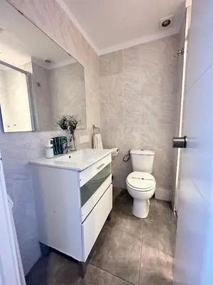 a white bathroom with a toilet and a sink at Plaza Spain Barcelona Apartments in Barcelona