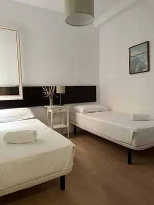 a bedroom with two beds and a table at Plaza Spain Barcelona Apartments in Barcelona