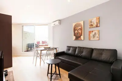 a living room with a black couch and a table at 1521 - AB Sagrada Família Comfort in Barcelona