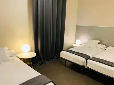 two beds in a room with two tables and two lamps at Super Balmes Guest House in Barcelona