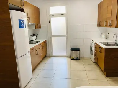 a kitchen with a white refrigerator and a tile floor at Super Balmes Guest House in Barcelona