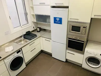 a small kitchen with a refrigerator and a sink at Super Balmes Guest House in Barcelona