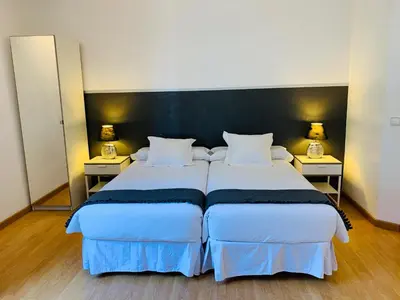 two beds in a hotel room with two lamps at Super Balmes Guest House in Barcelona
