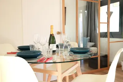 a dining room table with a bottle of wine on it at Amazing sea and Sagrada Familia views homey apartment in Barcelona