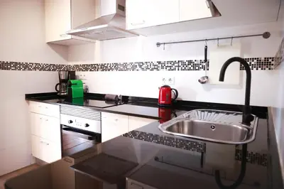 a small kitchen with a sink and a stove at Amazing sea and Sagrada Familia views homey apartment in Barcelona