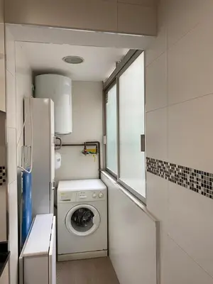 a small kitchen with a washing machine in it at Amazing sea and Sagrada Familia views homey apartment in Barcelona