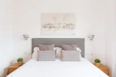 a white bedroom with a white bed with pillows at Stay U-nique Apartments Sant Antoni II in Barcelona