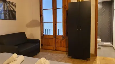 a room with a couch and a chair and a window at Barrio Gotico Apartments Escudellers in Barcelona