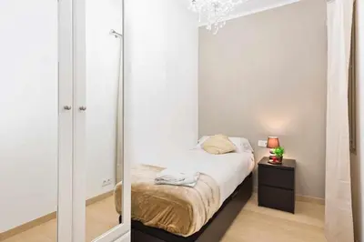 a small bedroom with a bed and a mirror at Apartment Eduardo in Barcelona