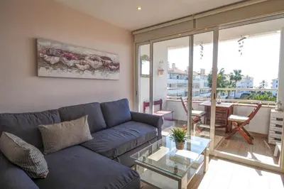 a living room with a blue couch and a glass table at Seaside Cozy Apartment by Hello Homes Sitges in Sitges