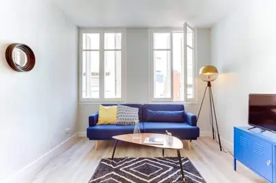 a living room with a blue couch and a table at Bright 2bdr In Trendy Gracia in Barcelona