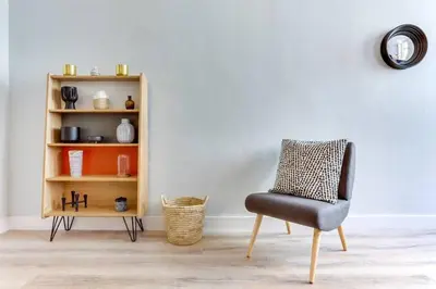 a chair in a room next to a book shelf at Bright 2bdr In Trendy Gracia in Barcelona