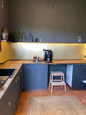 a kitchen with blue cabinets and a stool at Charming apartment in a duplex with garden & balcony in Cunit
