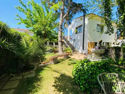 a house with a tree and a bench in the yard at Charming apartment in a duplex with garden & balcony in Cunit