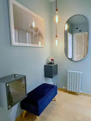 a room with a blue ottoman and a mirror at Abbott apartment - 1 min from the beach - 100m2 - sleeps 8 in Sitges