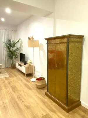 a living room with a large wooden cabinet in a room at Lovely New apartment 20 minutes from Barcelona center. in Barcelona