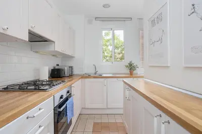 a kitchen with white cabinets and a stove top oven at Livefull 2bdr In Trendy Gracia in Barcelona