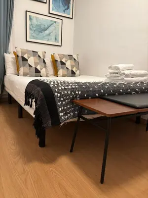 a bed with a table in a room at Livefull 2bdr In Trendy Gracia in Barcelona