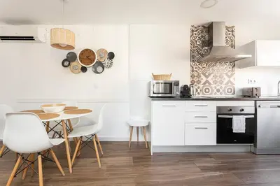 a kitchen with white cabinets and a table and chairs at Stylish&bright Close To Subway in Esplugues de Llobregat