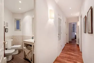 a white bathroom with a toilet and a sink at Central 2 Bedroom By Sagrada Familia in Barcelona