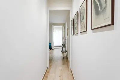 a hallway with framed art on the walls at Lovely Designed House Connected To Center in Cornellà de Llobregat