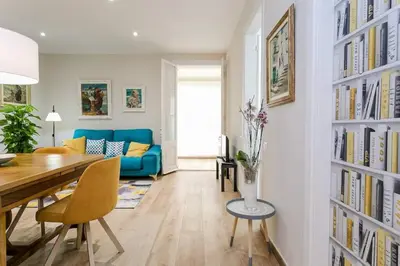 a living room with a table and a blue couch at Lovely Designed House Connected To Center in Cornellà de Llobregat