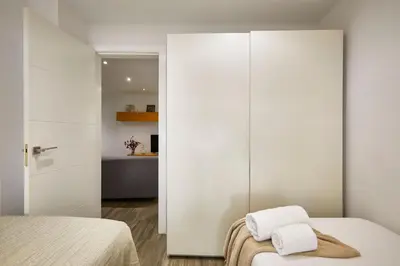 a bedroom with white walls and a bed with two towels at BBarcelona Sant Pau Flat in Barcelona