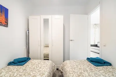two beds in a room with white cabinets at LOVELY APARTMENT Barca 2 in Sant Adria de Besos