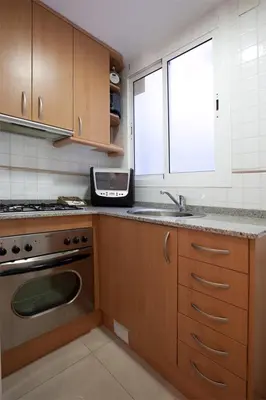 a kitchen with a sink and a stove and a window at rentBCN Gracia Jardinets in Barcelona