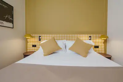 a large white bed with two pillows on it at H Regas Adults Only in Barcelona