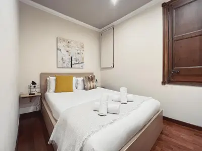 a white bedroom with a bed with two towels on it at Stay U-nique Apartments Industria II in Barcelona