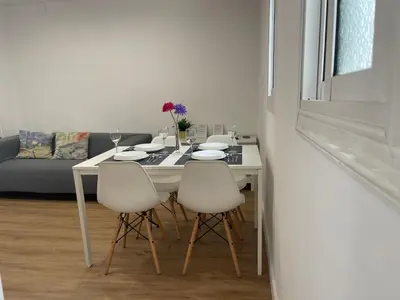 a white dining room table with four white chairs at Apartamento Kemacu in Barcelona