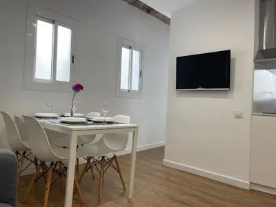 a white dining room with a table and chairs at Apartamento Kemacu in Barcelona