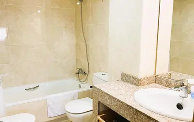 a bathroom with a sink and a toilet and a tub at Onze - primera línea de mar con piscina in Cubelles