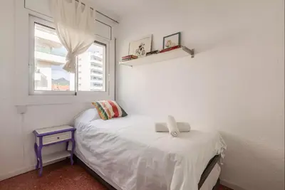 a small bedroom with a bed and a window at Apartment Muralla in Vilassar de Mar