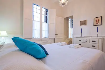 a white bedroom with a blue pillow on a bed at Stay U-nique Apartments Gaudi II in Barcelona