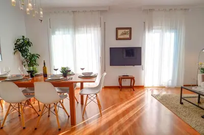 a dining room with a table and chairs and a television at San Sebastian Apartment by Hello Homes Sitges in Sitges