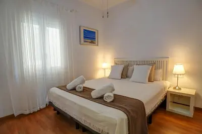 a bedroom with a bed with two pillows on it at San Sebastian Apartment by Hello Homes Sitges in Sitges