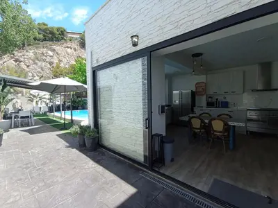 a sliding glass door leading to a kitchen and a patio at Edard's Great House in Castelldefels