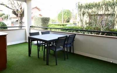 a table and chairs on a balcony with grass at Apartamento 2 habitaciones y magnífica terraza in Castelldefels