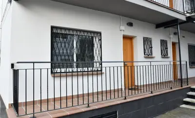 a balcony of a building with a gate and stairs at Apartamento 2 habitaciones y magnífica terraza in Castelldefels
