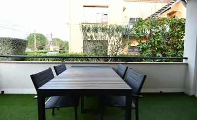 a table and chairs on a balcony with grass at Apartamento 2 habitaciones y magnífica terraza in Castelldefels