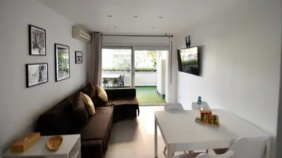 a living room with a couch and a table at Apartamento 2 habitaciones y magnífica terraza in Castelldefels