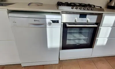 a white kitchen with a stove and a dishwasher at Opening Doors Vilassar. Family house Beach & Relax in Vilassar de Mar