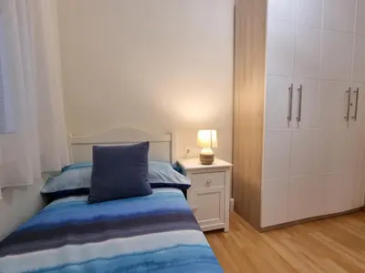 a bedroom with a bed with a blue pillow and a cabinet at Apartment PICNIC SANTS in Barcelona